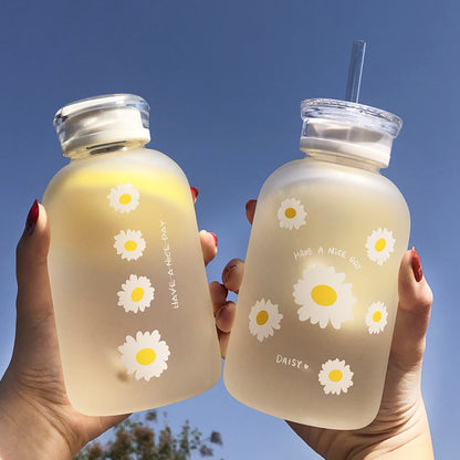 Una taza de vidrio de borosilicato de alta calidad con tapa doble de verano, resistente a altas temperaturas, taza de agua con pajita graduada, taza esmerilada Daisy, venta al por mayor 