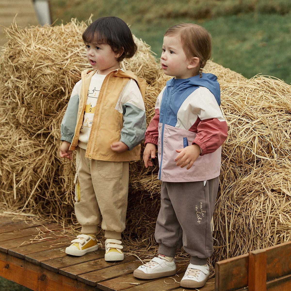 Ropa para niños en la primavera de 2024, el nuevo abrigo cortavientos para niños y niñas está empalmado y contrastado con la capucha cortavientos coreana.