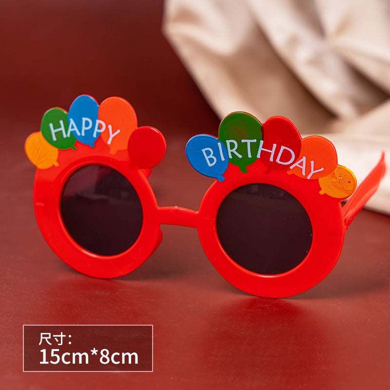 Un pequeño libro rojo con pequeñas gafas de margaritas, accesorios para fotografías de fiestas de cumpleaños en línea, gafas de cumpleaños divertidas y creativas para niños. 